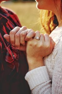 Man and woman making a pinky promise with one another represents accountability and support. 