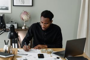 A man tries to figure out his budget. Learn how Black therapist huntsville Alabama can help your 