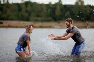 A couple is laughing and splashing in a lake. This represent the success and support online marriage counseling in Alabama provides. Contact a therapist in Huntsville, AL, or search “marriage counselors huntsville al” today.